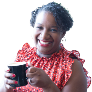 K Paige Engle smiling holding a coffee cup in a red dress